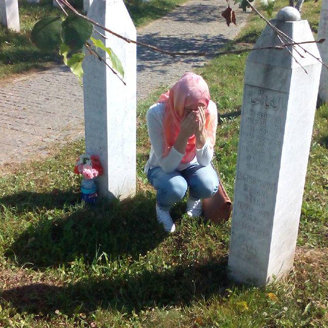 My daughter between two graves, where they buried her father and uncle.. Al Fatiha